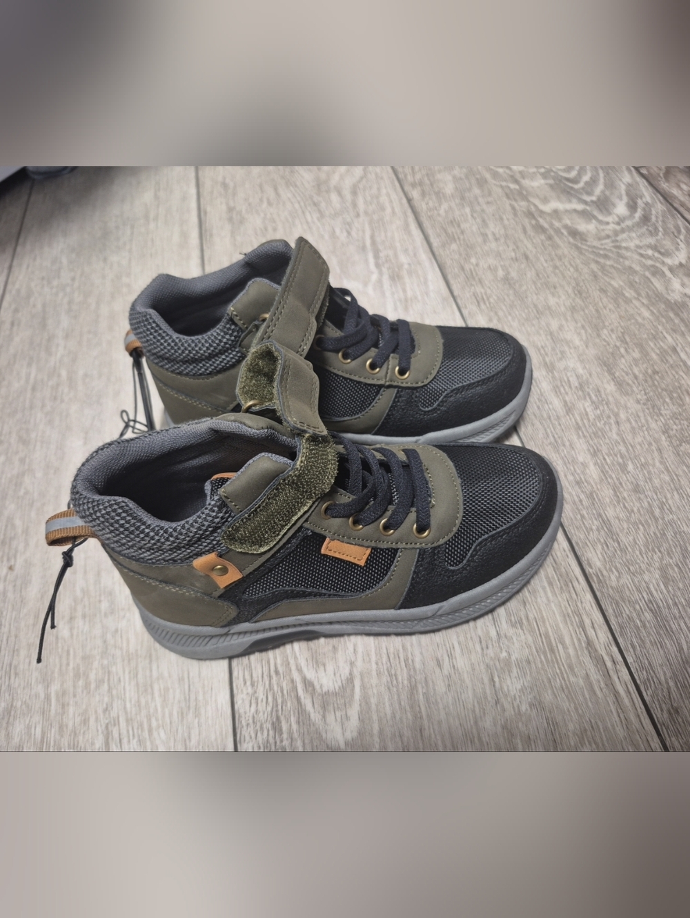 mid-top sneakers feature a mix of khaki, black, and orange accents. Durable